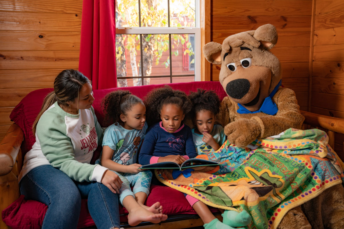 Boo Boo Bear bedtime story visit with kids at Jellystone Park South Haven Boo Boo Bear reading a bedtime story to kids in a cabin at Jellystone Park South Haven