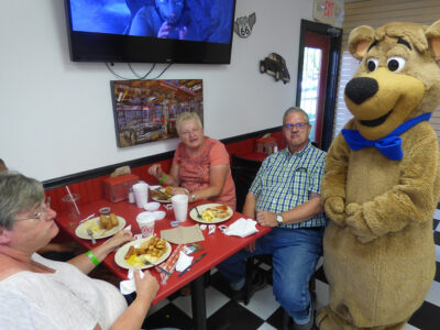 Family dining with Boo Boo Bear inside the Cartoon Café at Jellystone Park South Haven
