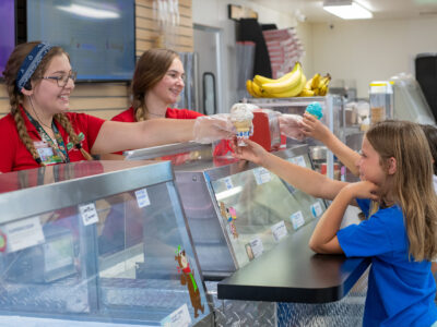 Child receiving ice cream from staff at Cartoon Café in Jellystone Park South Haven
